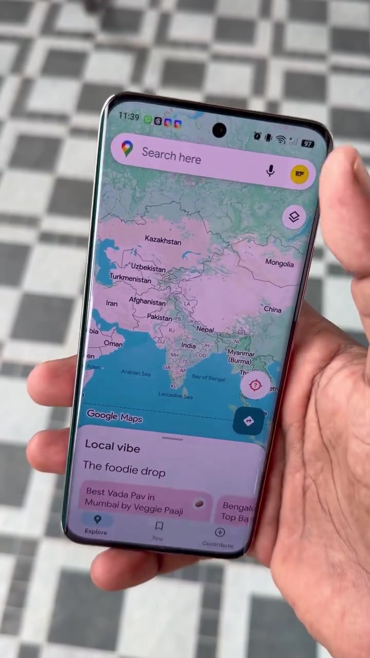 Ponsel menampilkan beranda Google Maps dengan peta dan kolom pencarian