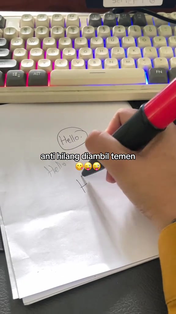 Ujung pulpen jumbo merah menyentuh kertas saat menulis.