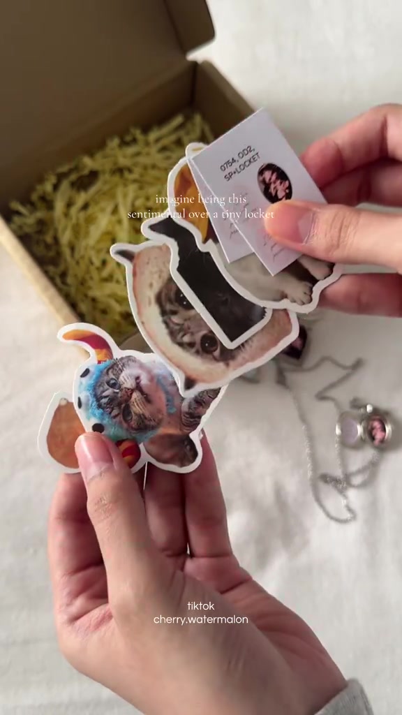 Tangan memegang kartu contoh berisi foto kecil dan bentuk liontin locket