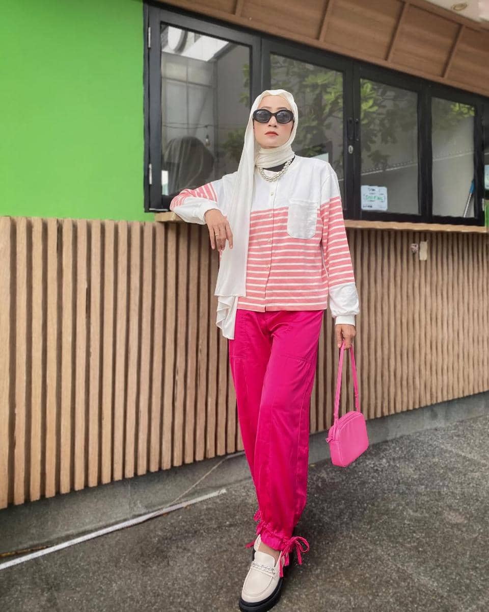 Loafers putih dipadukan dengan celana pink untuk tampilan kasual cerah