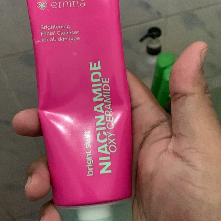 Tube Emina Brightening Facial Cleanser berwarna pink dipegang dari dekat