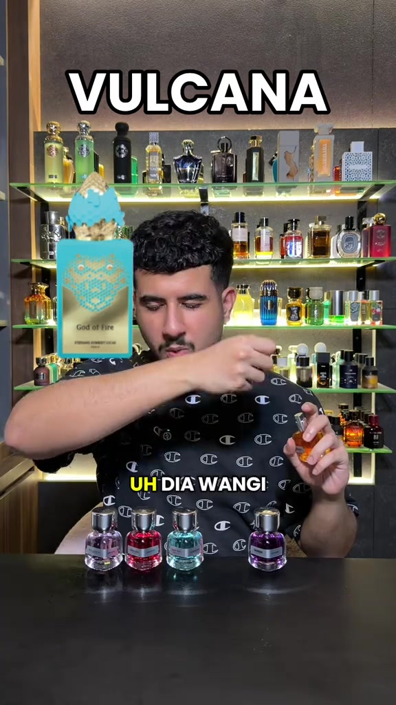 Kreator menampilkan botol dan kotak parfum saat membahas Vulcana di depan rak parfum