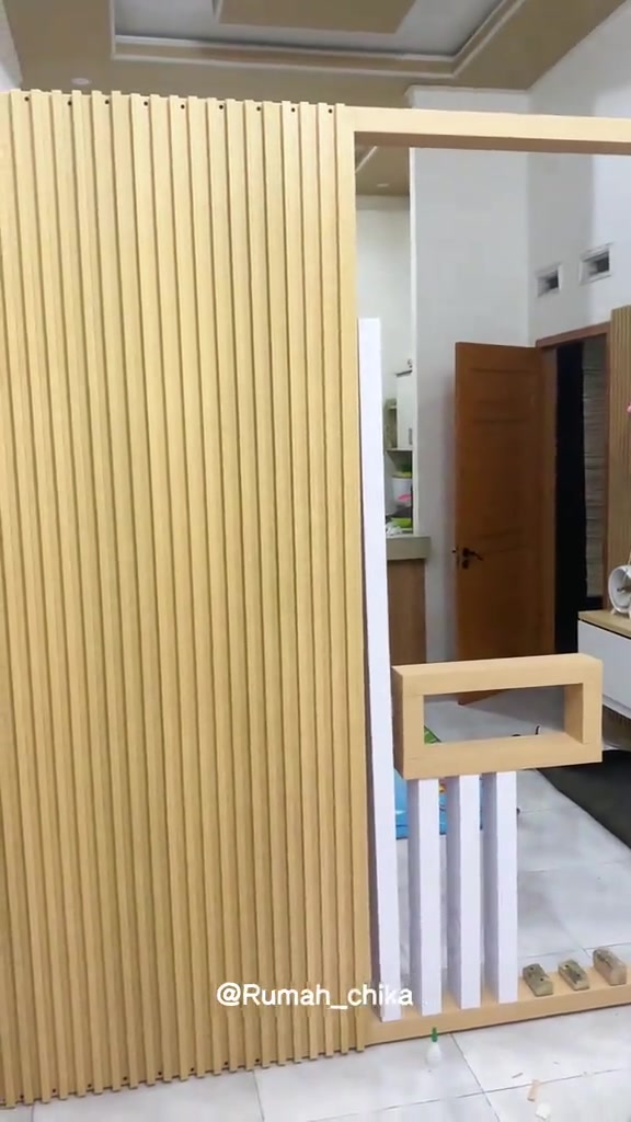 Partisi kisi WPC berengsel dengan sisi panel terbuka di dalam rumah
