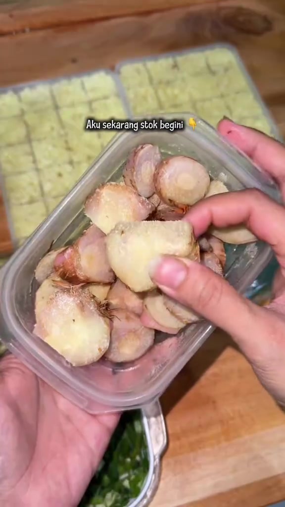 Potongan jahe tersimpan dalam wadah dengan porsi beku di belakangnya