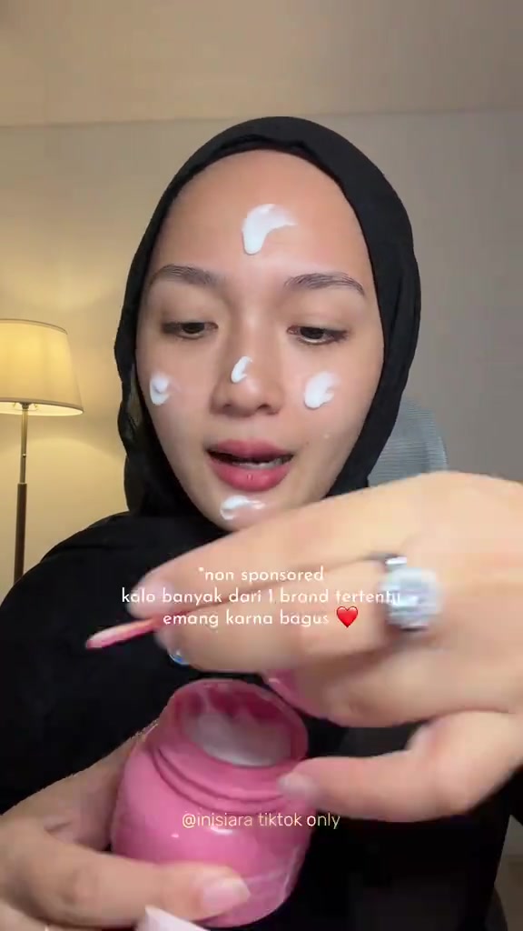 Pelembap ditotolkan ke wajah sebelum tahap complexion, dengan wadah moisturizer di tangan