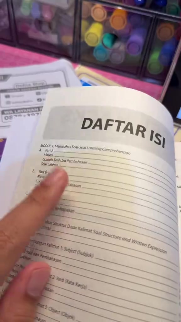 Buku TOEFL terbuka pada halaman daftar isi dan modul latihan
