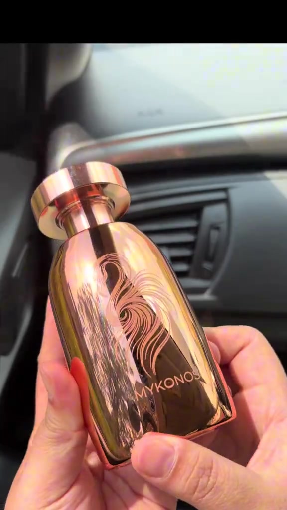Botol rose gold Mykonos Marbella dipegang di dalam mobil