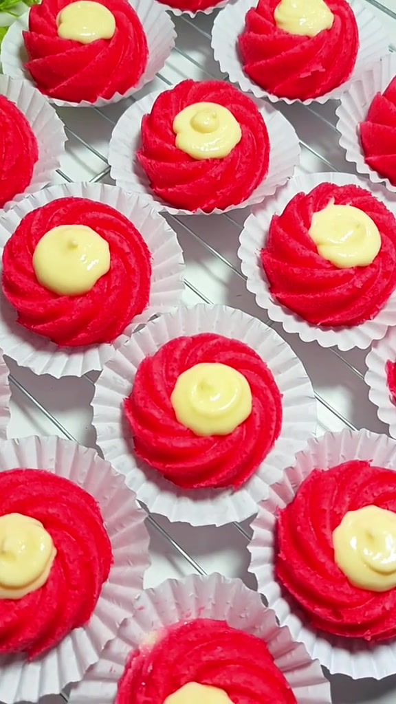 Bolu mini red velvet matang dengan isian saus keju di tengahnya, tersusun di rak pendingin
