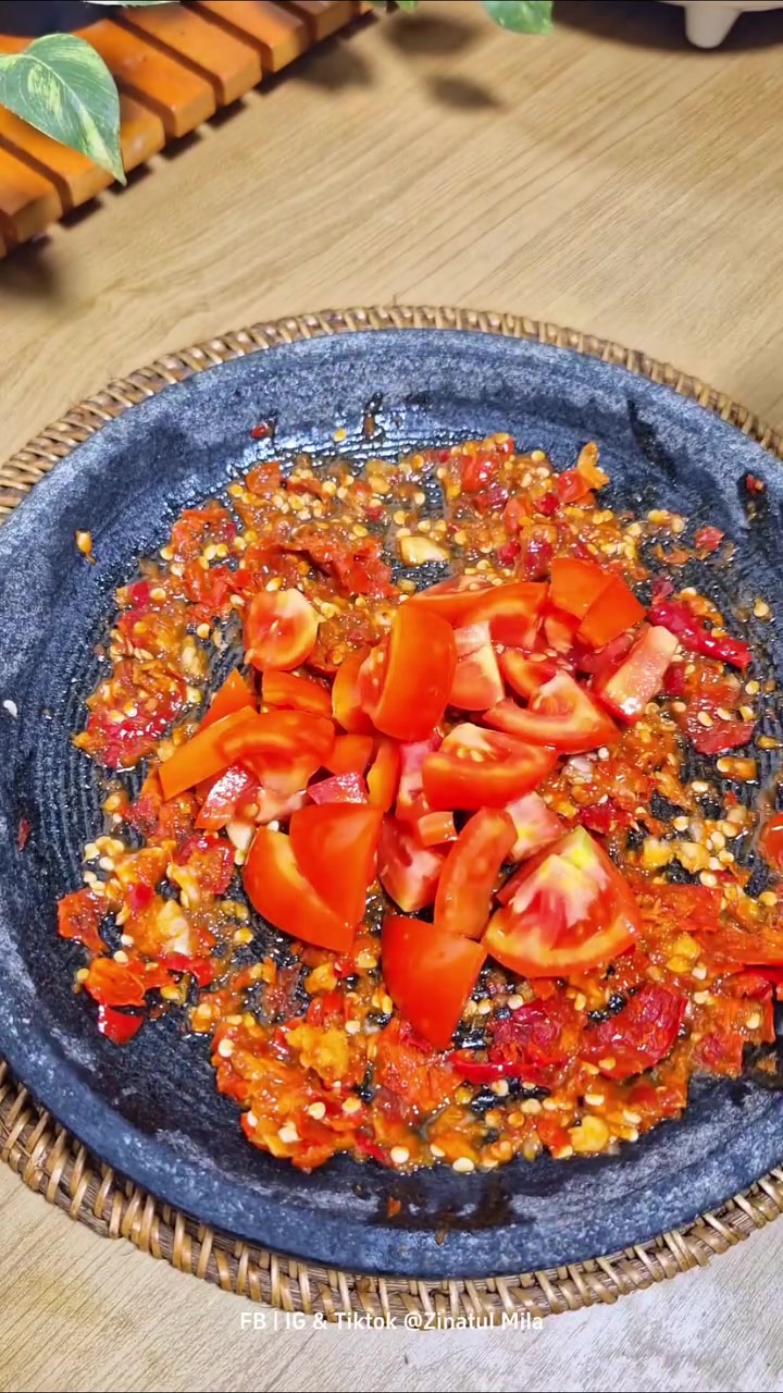 Sambal merah kasar dan potongan tomat di atas cobek