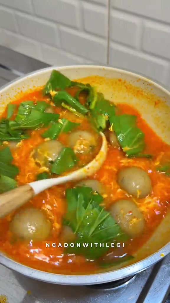 Cilok kuah seblak merah oranye dengan daun sawi hijau