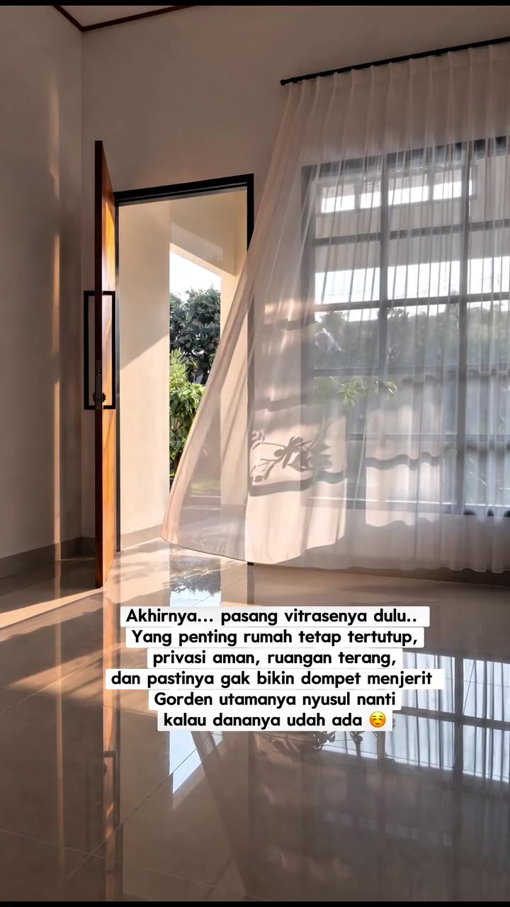Vitrase tipis pada jendela tinggi yang tetap membiarkan cahaya masuk