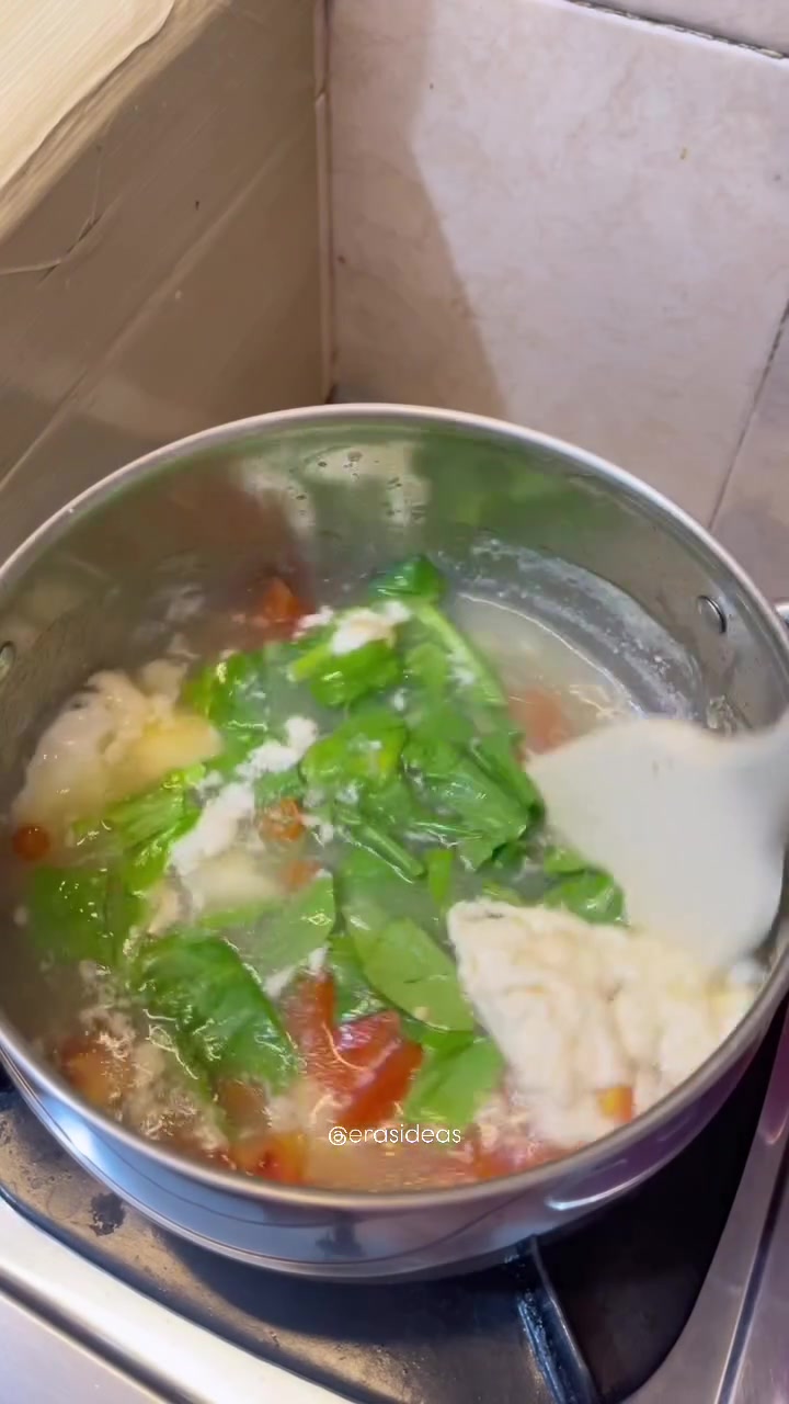 Sup berisi telur, pakcoy, dan potongan tomat di dalam panci