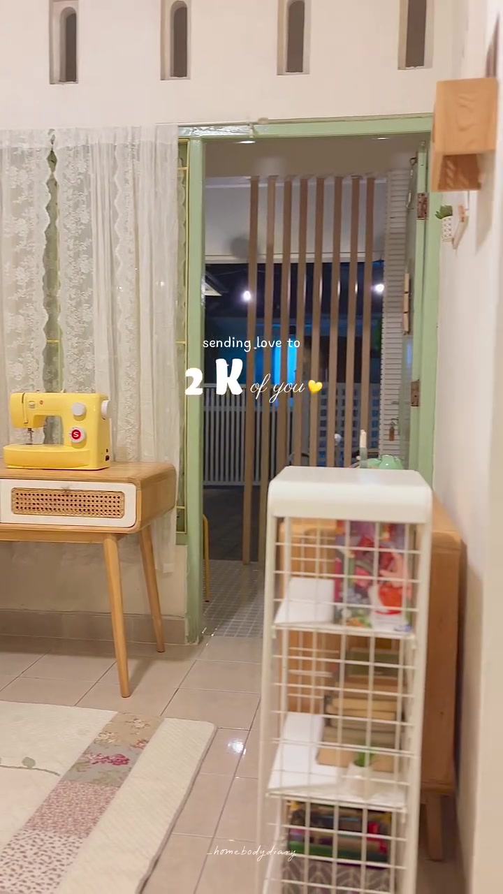 Sudut ruang keluarga bernuansa pastel dengan sofa kuning dan mesin jahit
