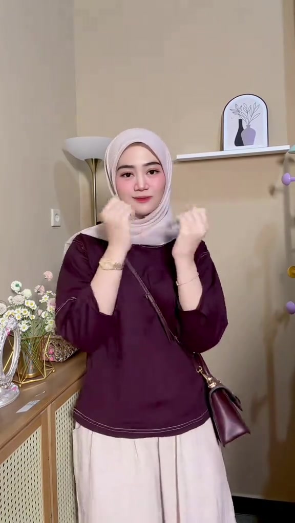 Atasan burgundy dengan celana putih dan tas bahu gelap